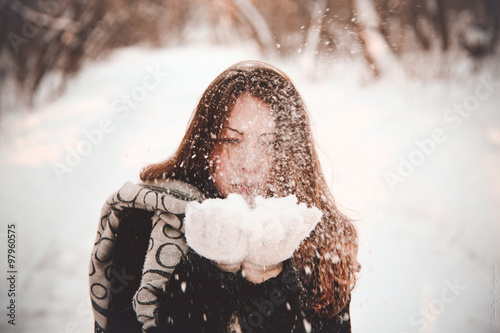 девушка сдувает снег с перчаток