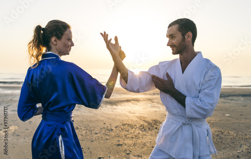 Couple training martial arts on the beach