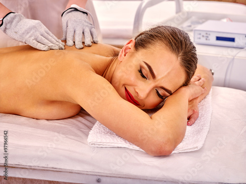 Woman receiving electricity gloves massage at beauty salon.