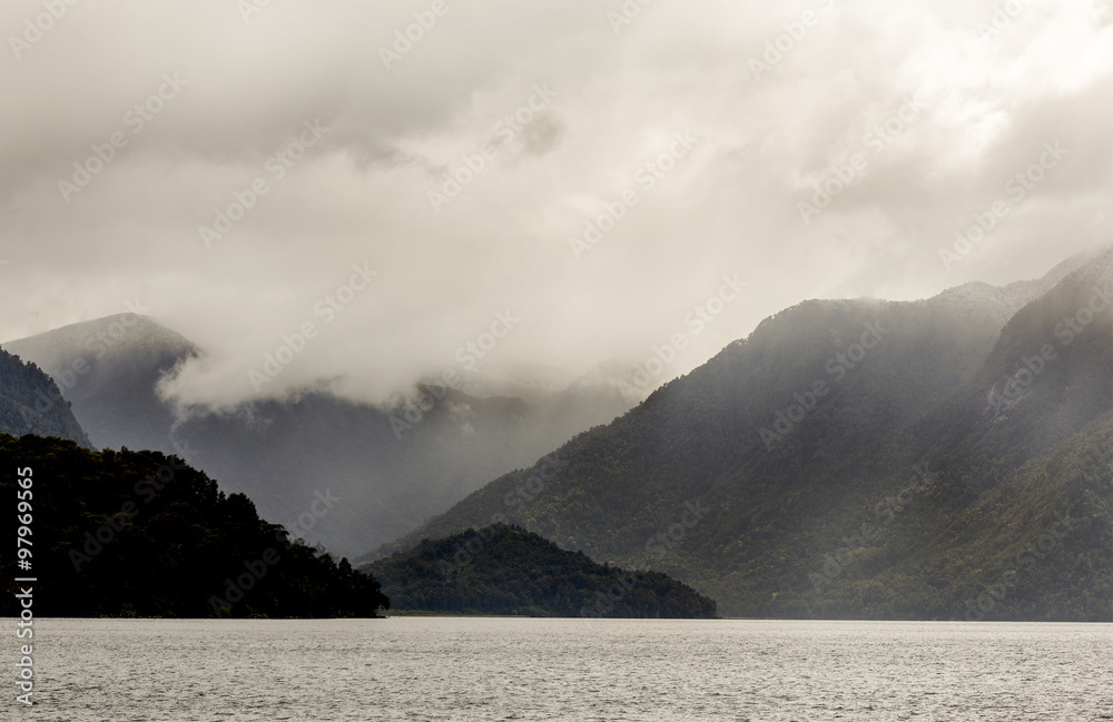 Fototapeta premium rain cloud on top of mountains and a lake