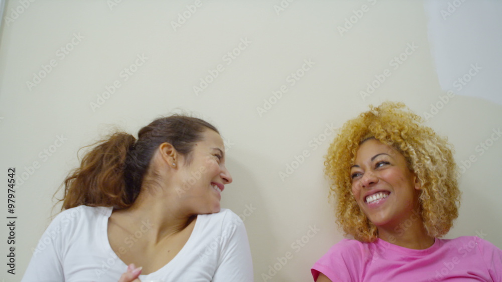 Happy attractive gay female couple relax and take a break from painting in new home. Happy attractive gay female couple relax and take a break from painting in new home.