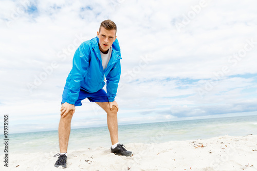 Man training on beach outside © Sergey Nivens