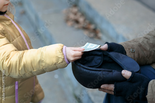 Somebody gives money to the beggar. 