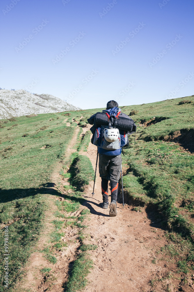 Climber man with a backpack walking in a path Climber man with a backpack walking in a path