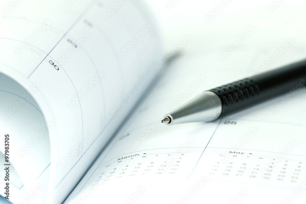 ball pen on opened lined diary book with calendar ball pen on opened lined diary book with calendar