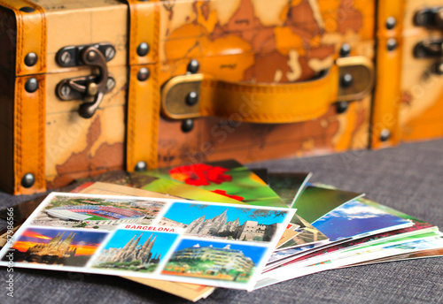Photography Colorful postcards of an old vintage leather suitcase on the background