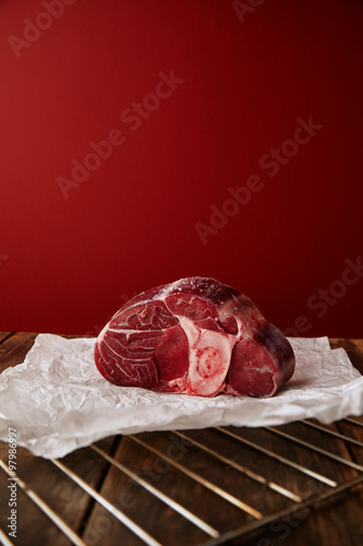 Presentetion of angus leg steak on wooden tablered background photo