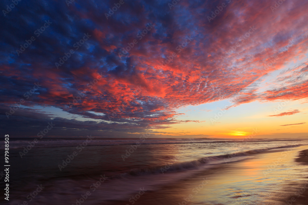 Beautiful colored clouds at the beach at sunset