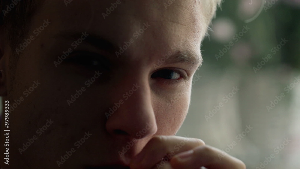 Mysterious boy sitting in the shadow and looking to the camera
Mysterious boy sitting in the shadow and looking to the camera
