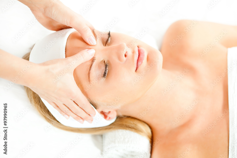 Young woman having forehead massage on spa treatment