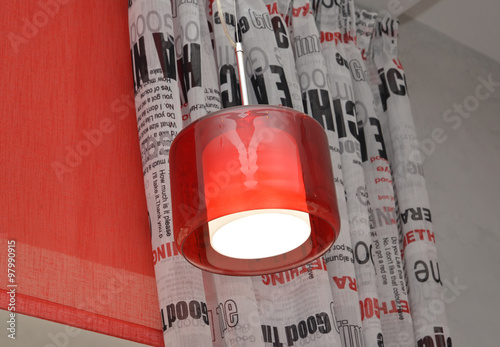 The lamp with a red plafond against a portiere and rolshtor