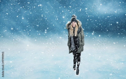 Junge Frau beim Spaziergang im Schneetreiben 