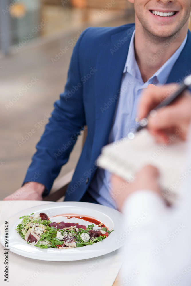 Skillful male cafe worker is serving a client Skillful male cafe worker is serving a client