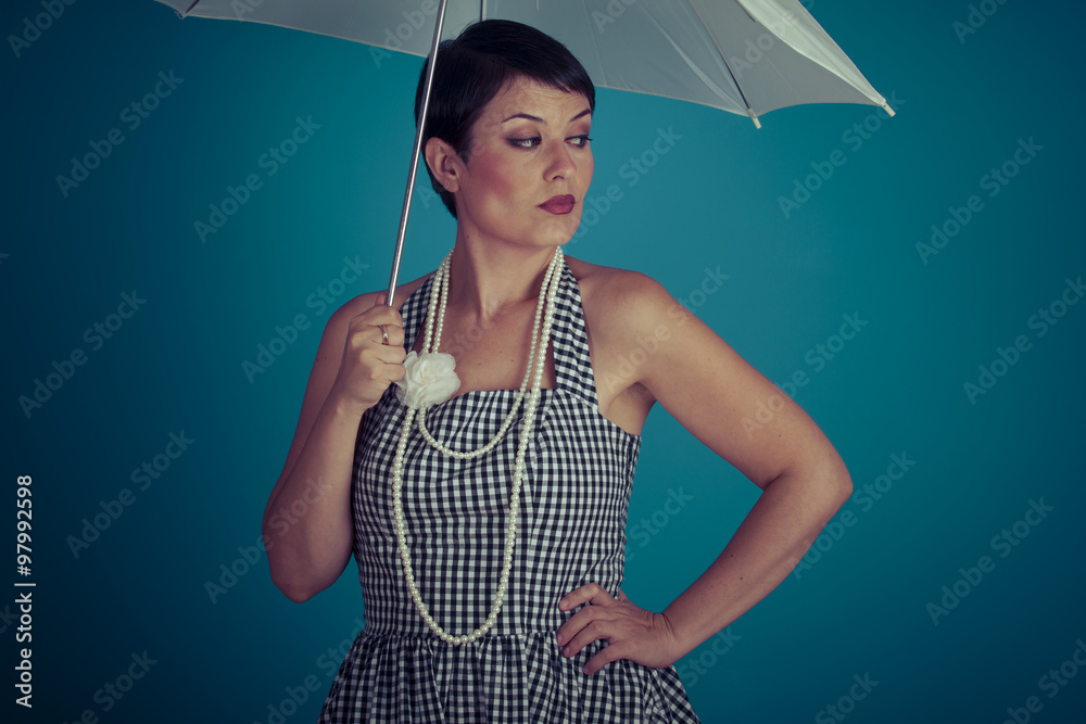Fototapeta premium girl vintage 50s dress with white umbrella over blue background