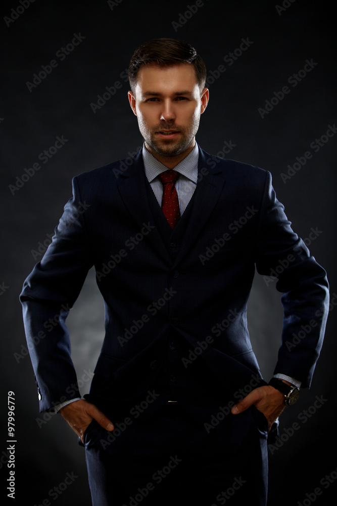 Obraz premium Handsome young business man standing on black background