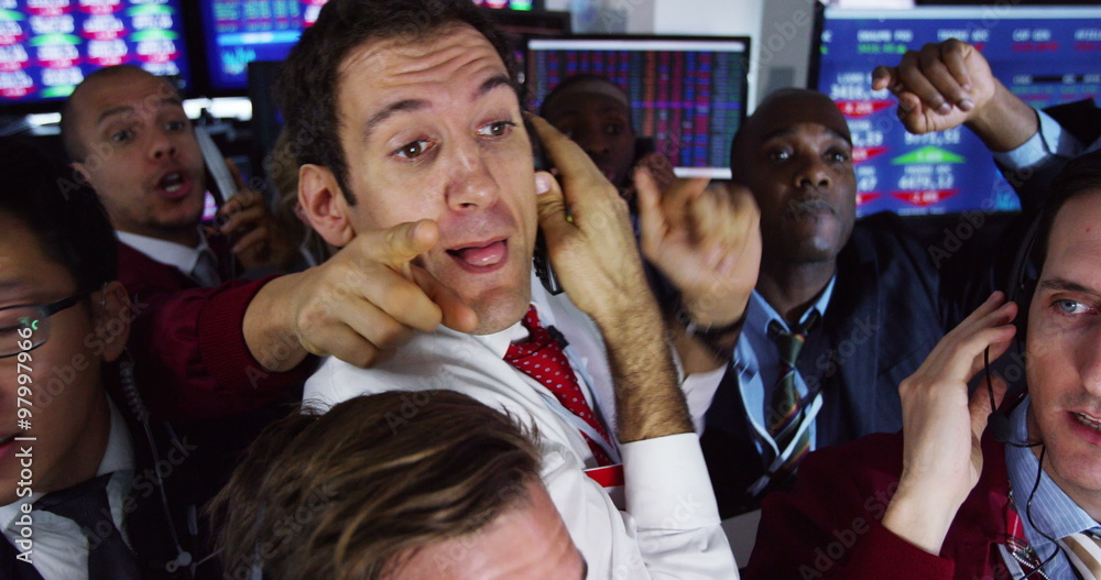  Diverse group of stockmarket traders frantically buying and selling on the trading floor. Shot on RED Epic.
