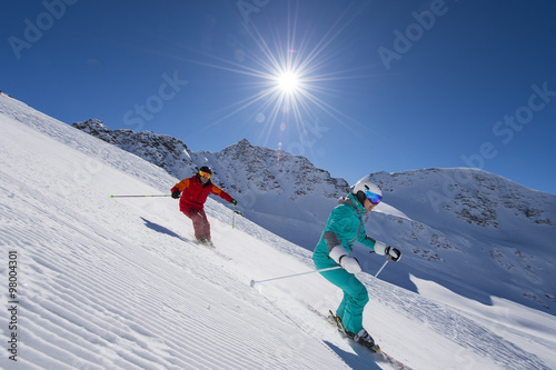  ski downhill with sun in the background