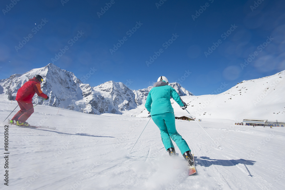 Skiing on skirun in the alps - prepared piste and sunny day
