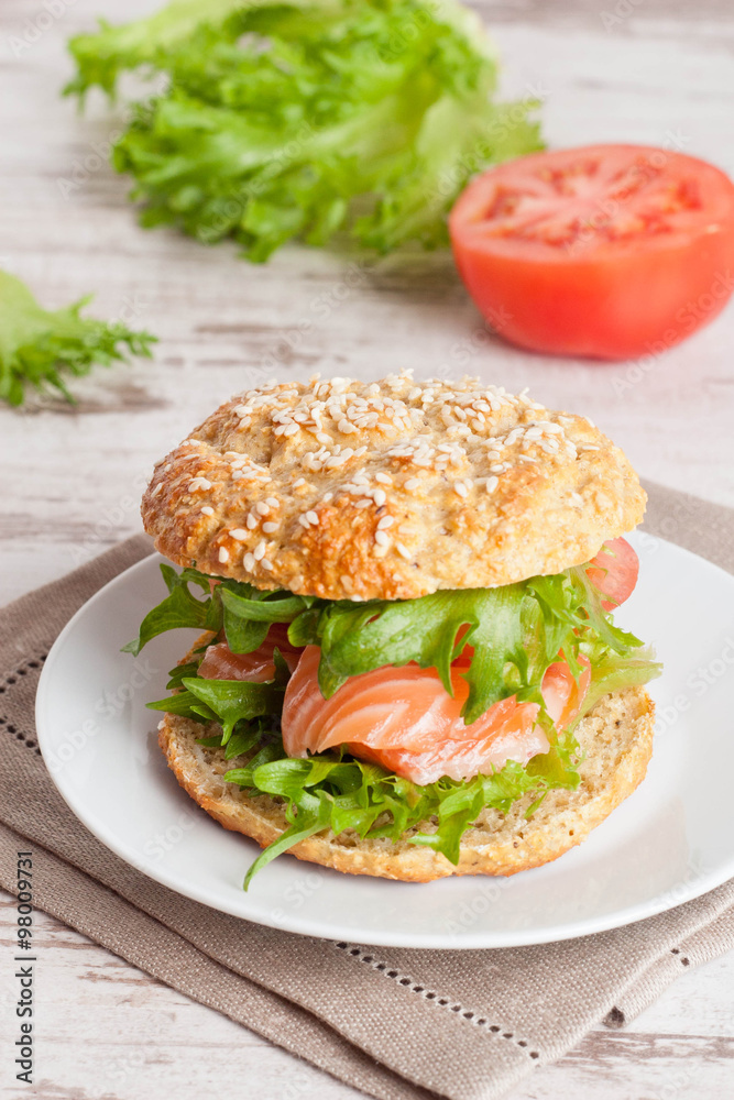 burger with smoked salmon and vegetables, close-up, vertical burger with smoked salmon and vegetables, close-up, vertical
