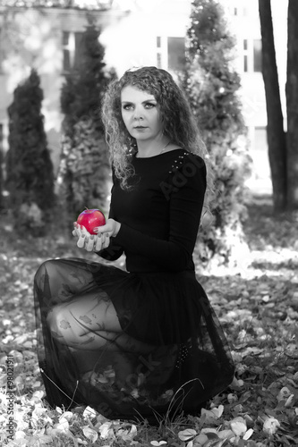 Obraz na płótnie The girl in a black dress with red apple in bw w salonie