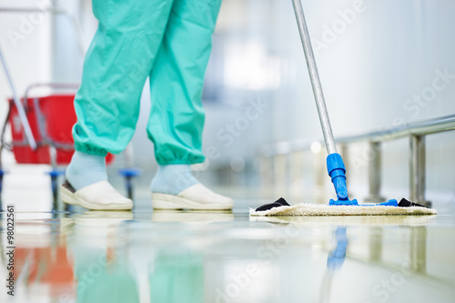 worker cleaning floor with mop photo