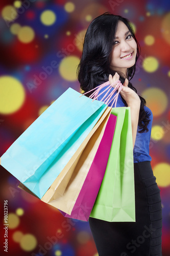 Shopper holds shopping bags with defocused background