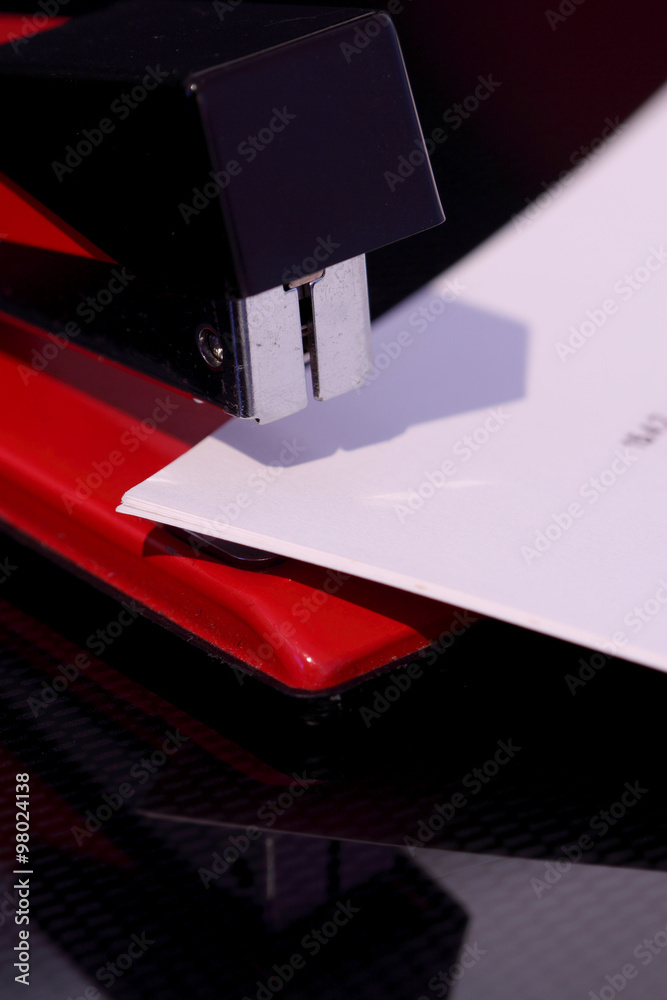 Obraz premium Stapler document / Stapler and document reflected on dark background