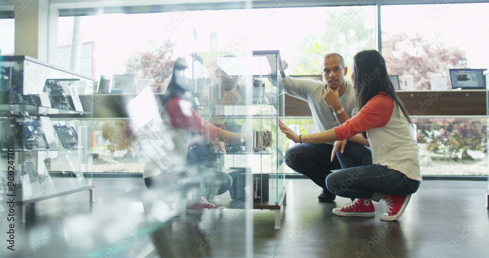 Couple shopping in consumer electronics store showroom