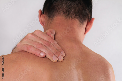 Close up of man rubbing his painful neck. Pain relief concept