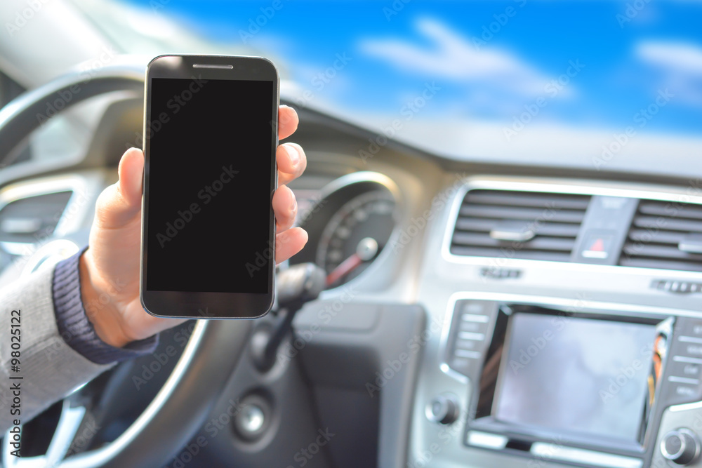 Smartphone hold by man inside a car while driving