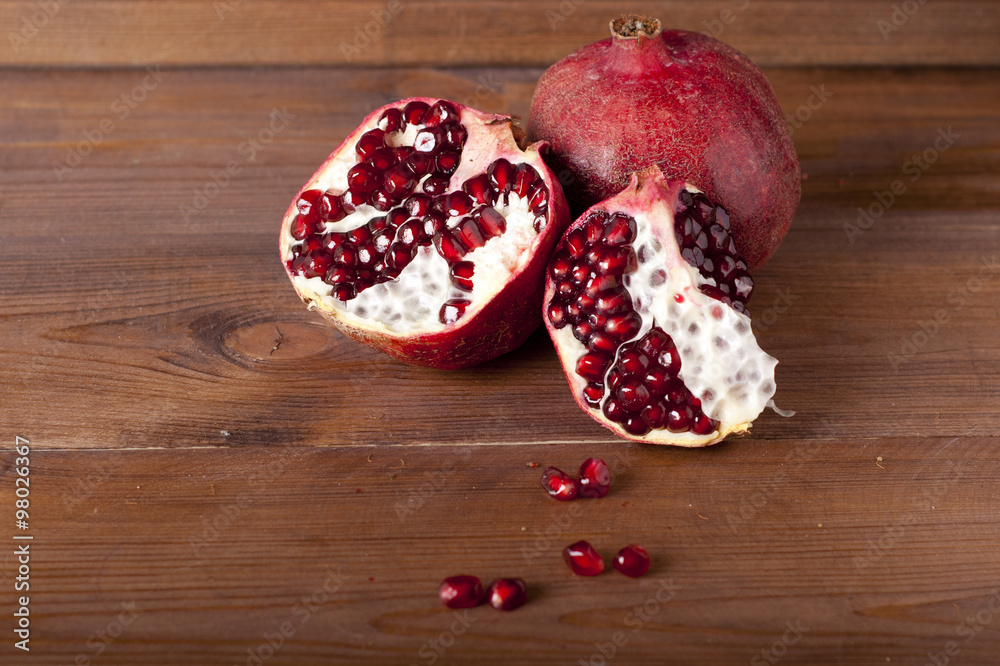 two ripe pomegranate on a wooden rustic background