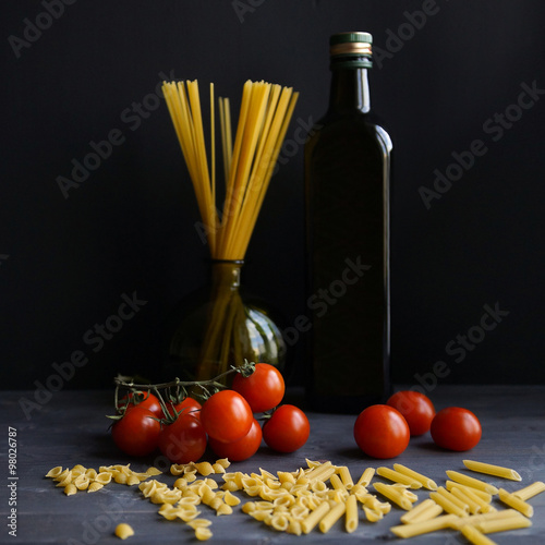 Pasta and tomatoes on a dark background, Italian still life