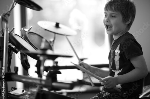 Happy child drumming and singing