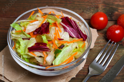 Fotografi salad with lettuce and carrots on a wooden background