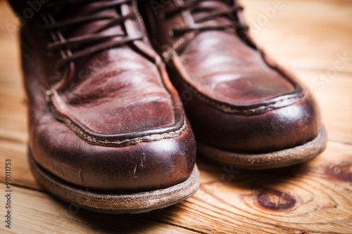 Brown leather boots on wooden background