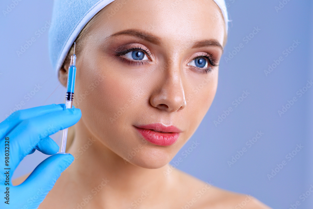 Cosmetic injection on the pretty woman face. Isolated on gray background Cosmetic injection on the pretty woman face. Isolated on gray background