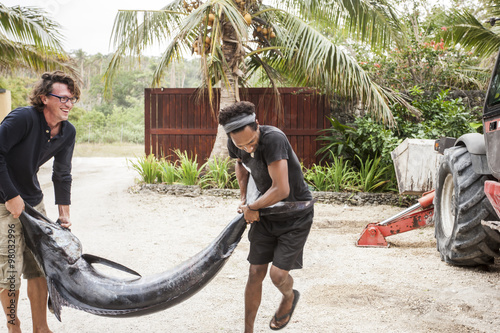 Two men carrying a huge swordfish photo