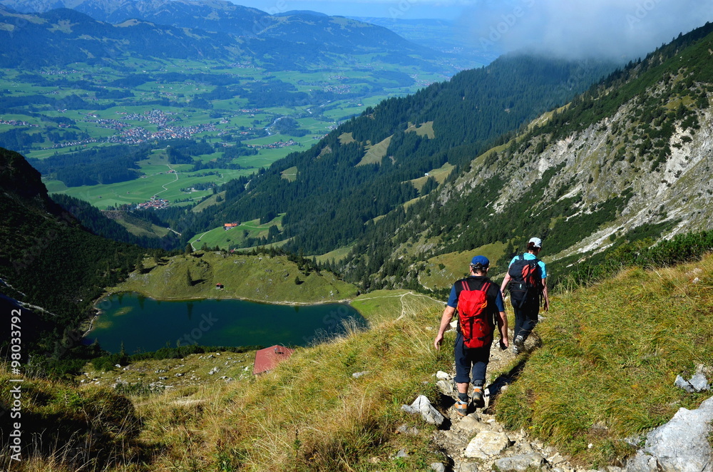 Paar bei Wanderung in den Alpen mit Ausblick auf See