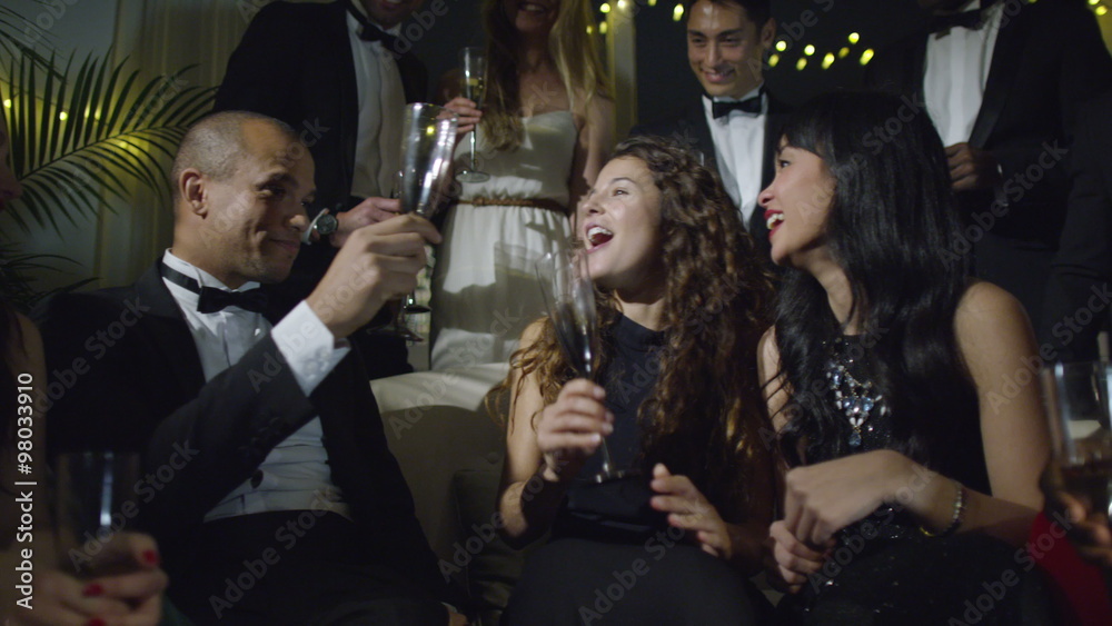  Happy group of friends at glamorous party, drinking champagne and celebrating