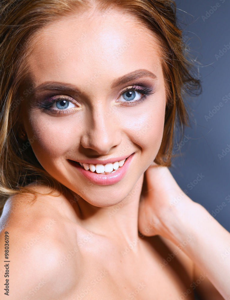Obraz premium Beautiful woman with curly long hair on dark background