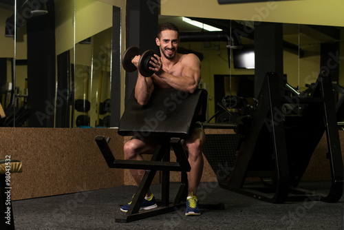 Bodybuilder Exercising Biceps With Dumbbells