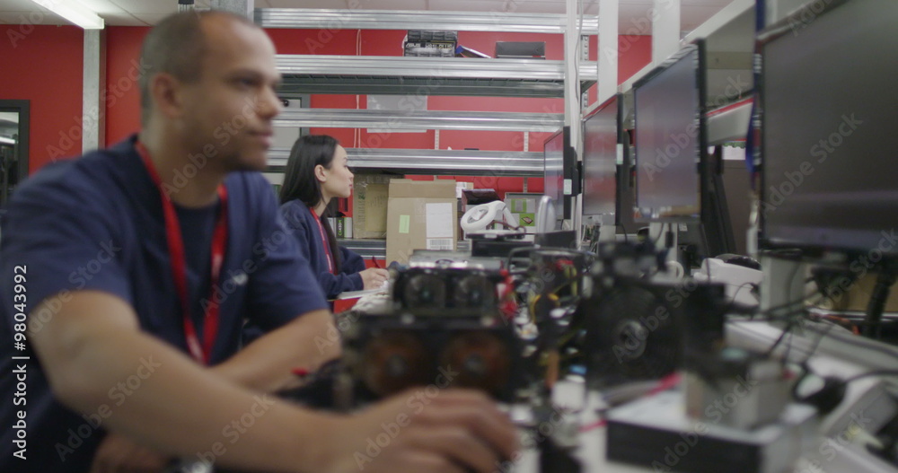 Workers in an electronics factory working on computer testing and repairs Workers in an electronics factory working on computer testing and repairs