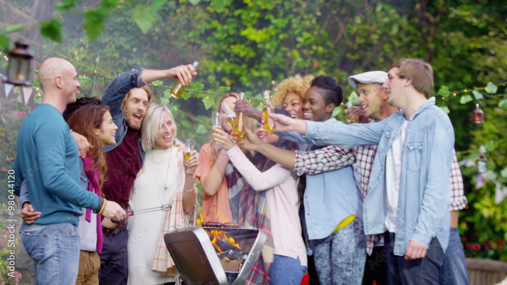  Happy group of friends at outdoor bbq raise their glasses for a toast