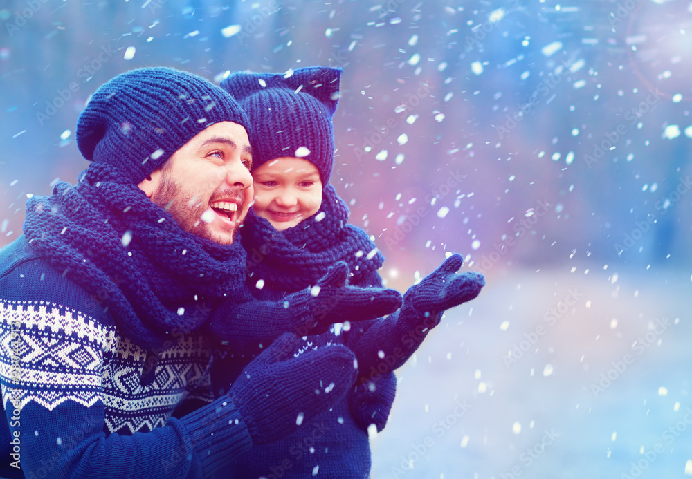 happy father and son having fun under winter snow happy father and son having fun under winter snow