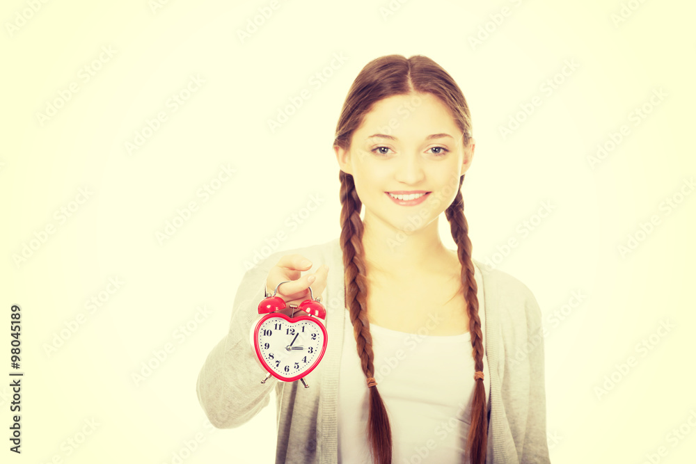 Happy teenage woman with alarmclock.