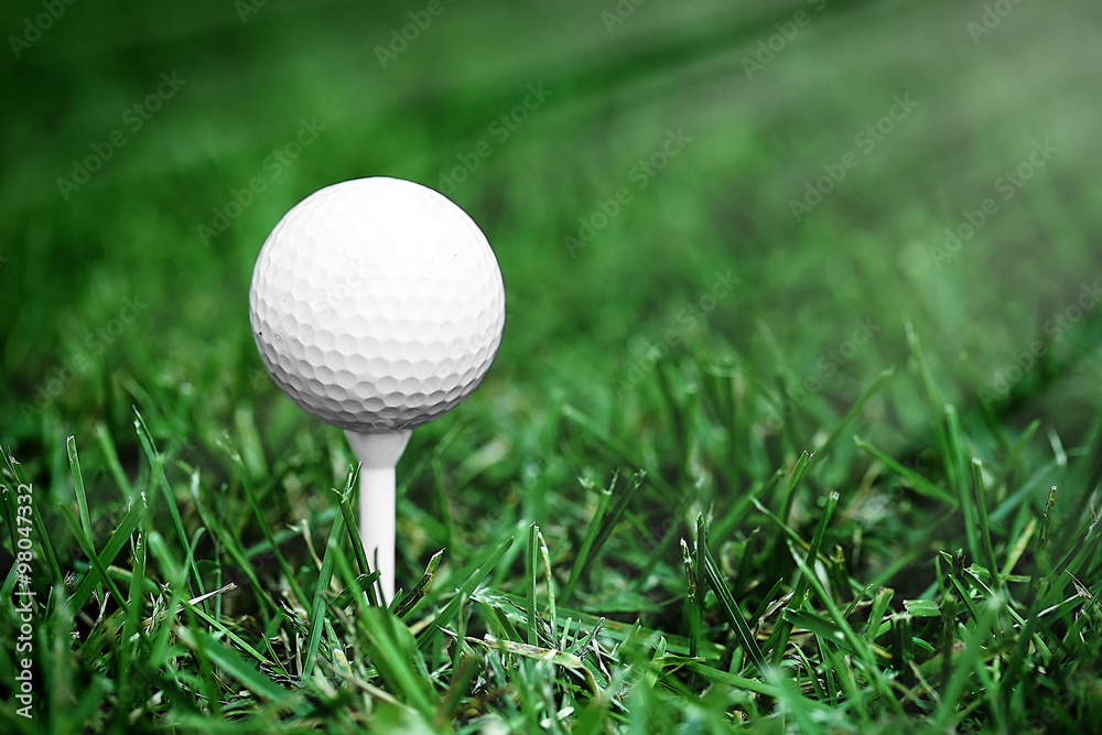 White golf ball on green grass background White golf ball on green grass background