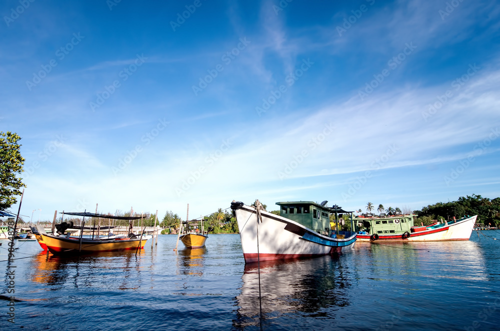 beautiful image of traditional fishing boat with reflection and blue sky at terengganu, malaysia beautiful image of traditional fishing boat with reflection and blue sky at terengganu, malaysia