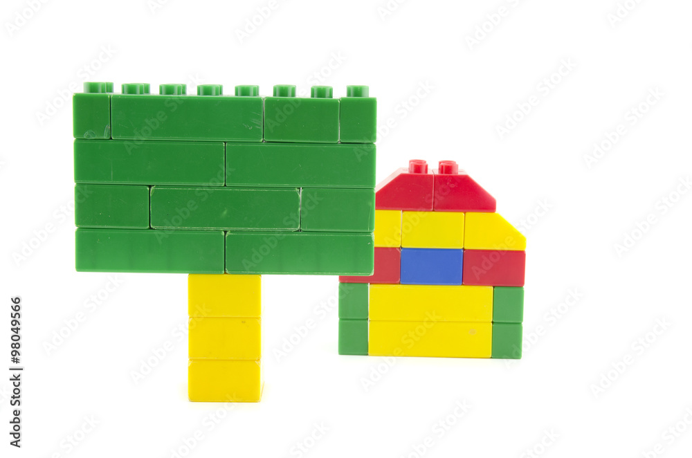 Obraz premium single home icon made from plastic building blocks and green signage isolated on white background