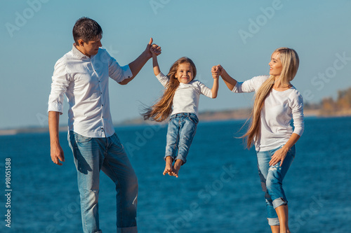 Happy family who playing on the beach. Concept of friendly familys