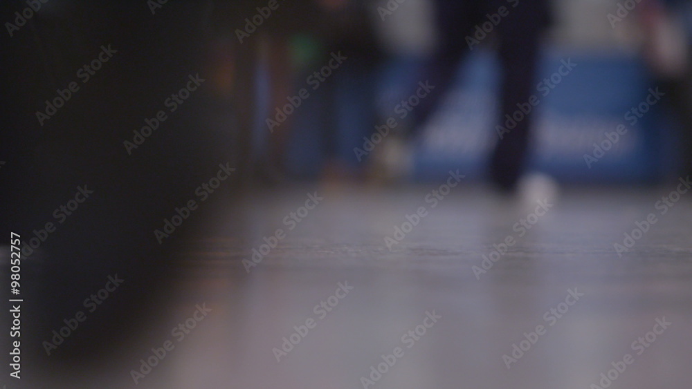 Low angle view of travellers' feet walking through a busy train station or airport. Low angle view of travellers' feet walking through a busy train station or airport.